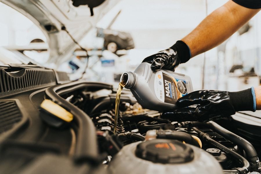 Fresh motor oil being poured into a car engine