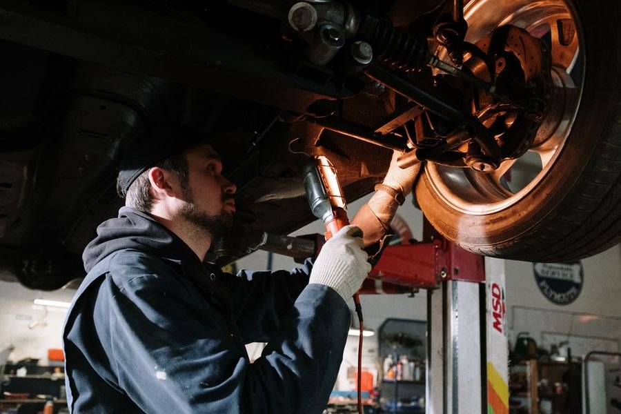Mechanic inspecting a car's wheel and brakes